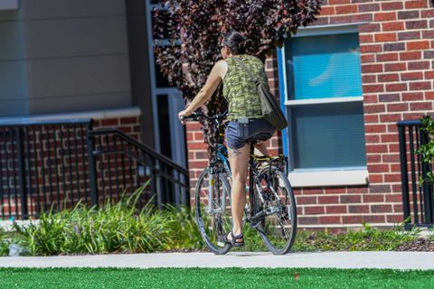 girl riding bike outside apartments