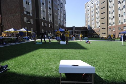 students playing cornhole on the lawn